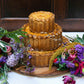 Three-tiered wedding cake with floral decorations on a wooden board.